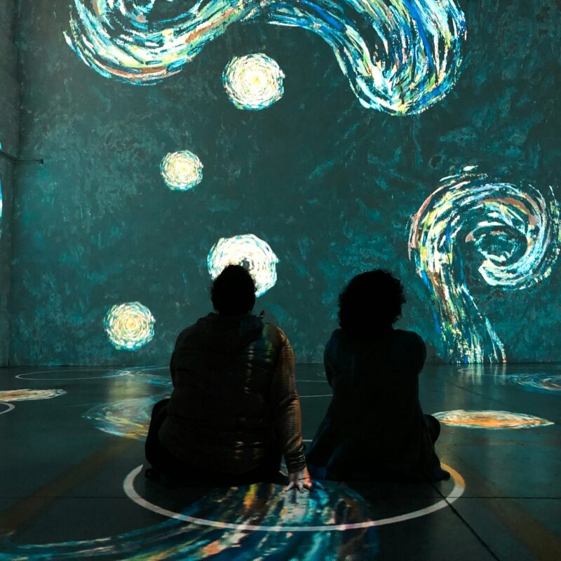 People sitting in physical distancing circles at Immersive Van Gogh Exhibit in Toronto Canada