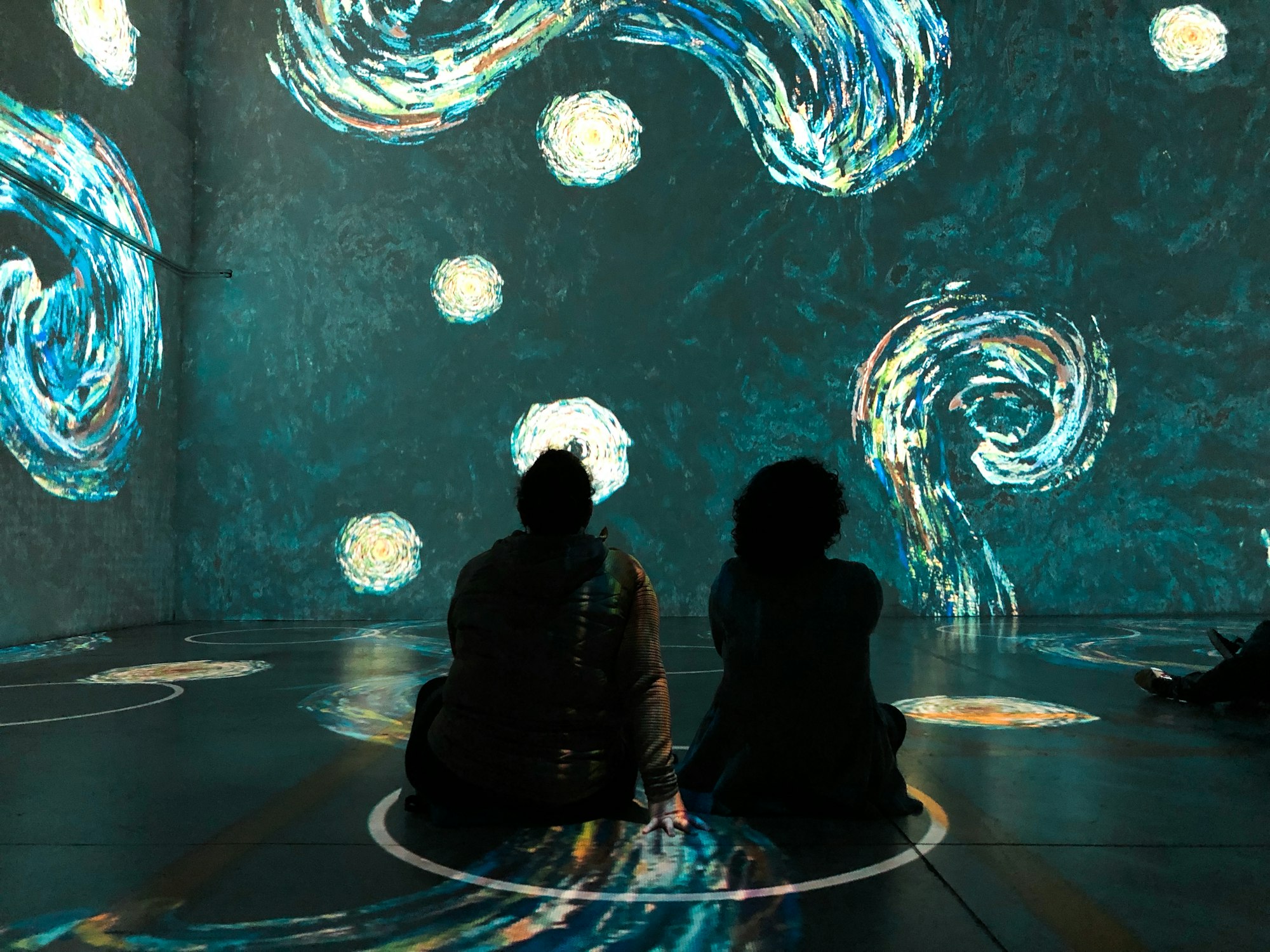 People sitting in physical distancing circles at Immersive Van Gogh Exhibit in Toronto Canada
